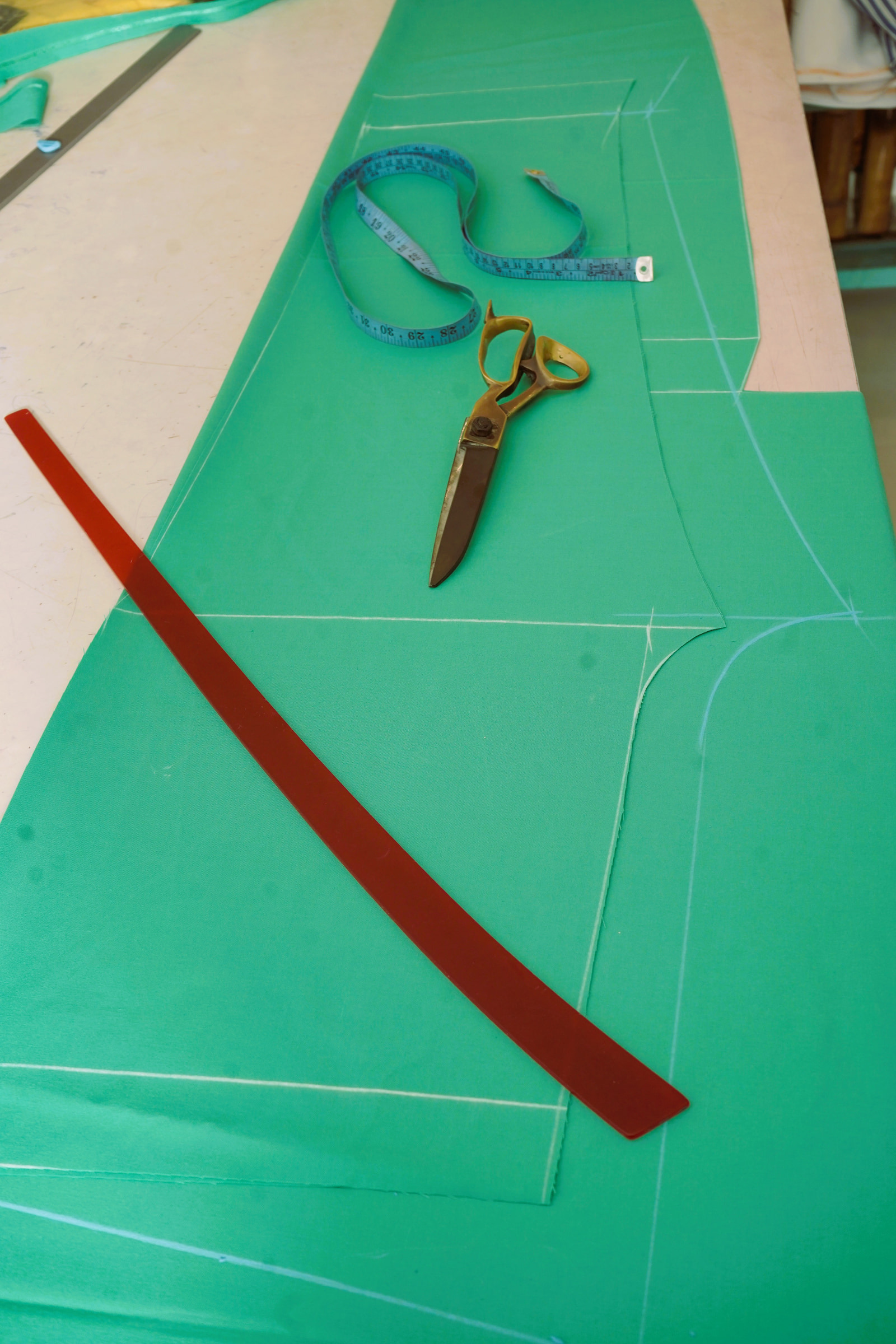 Shears and a tape measure resting on the chalked cloth