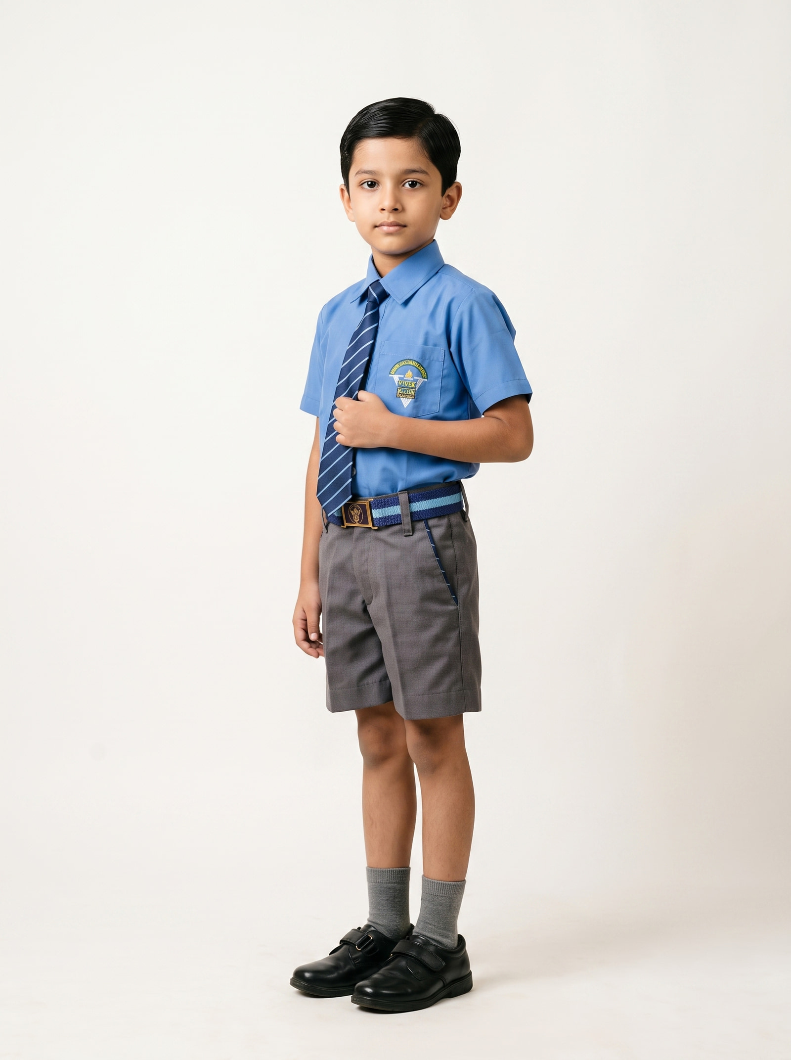 Blue shirt, house tie and grey shorts, with belt and buckle to the school specification.